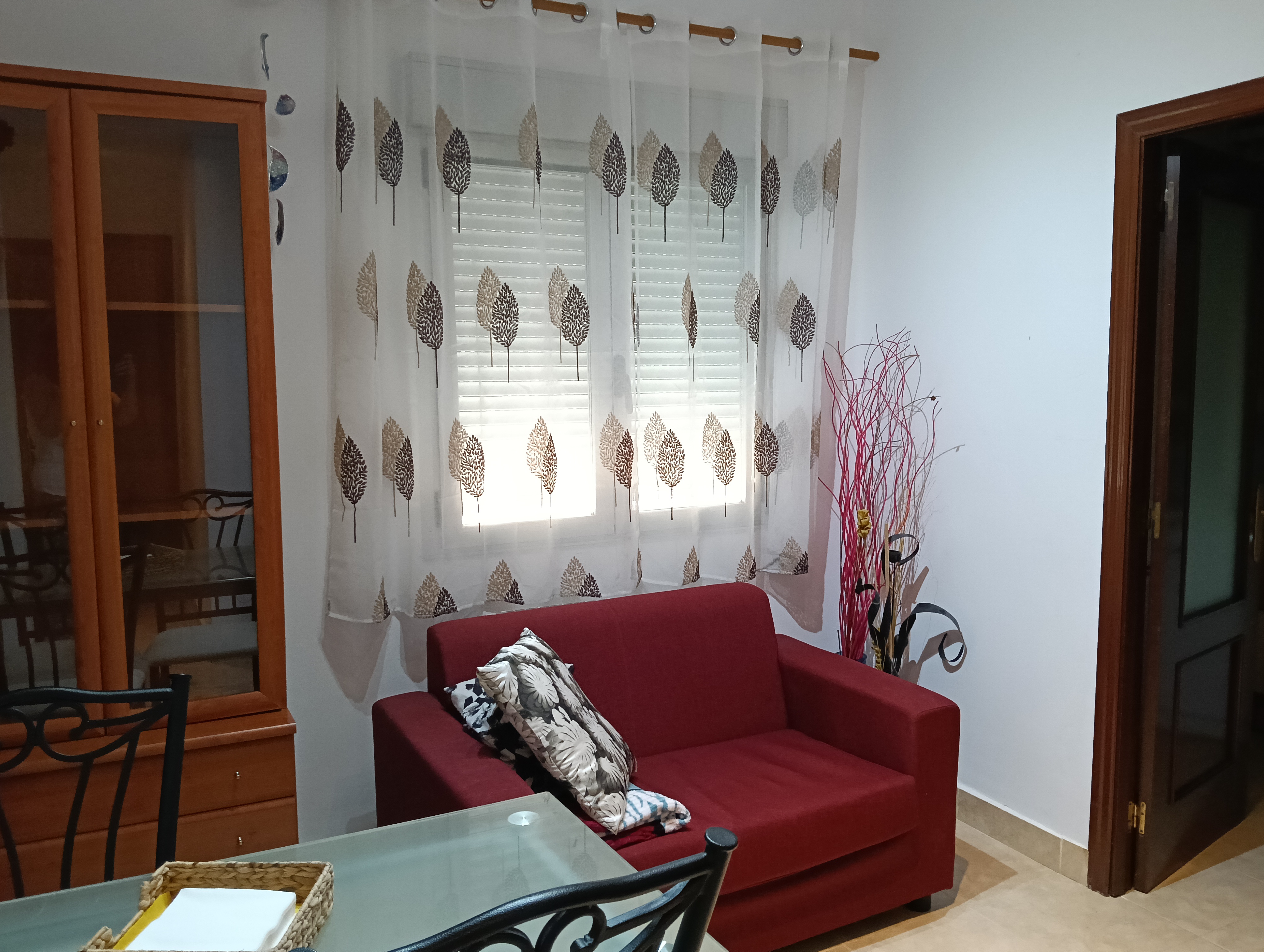 Ventana de la sala, sofá y puerta de la cocina